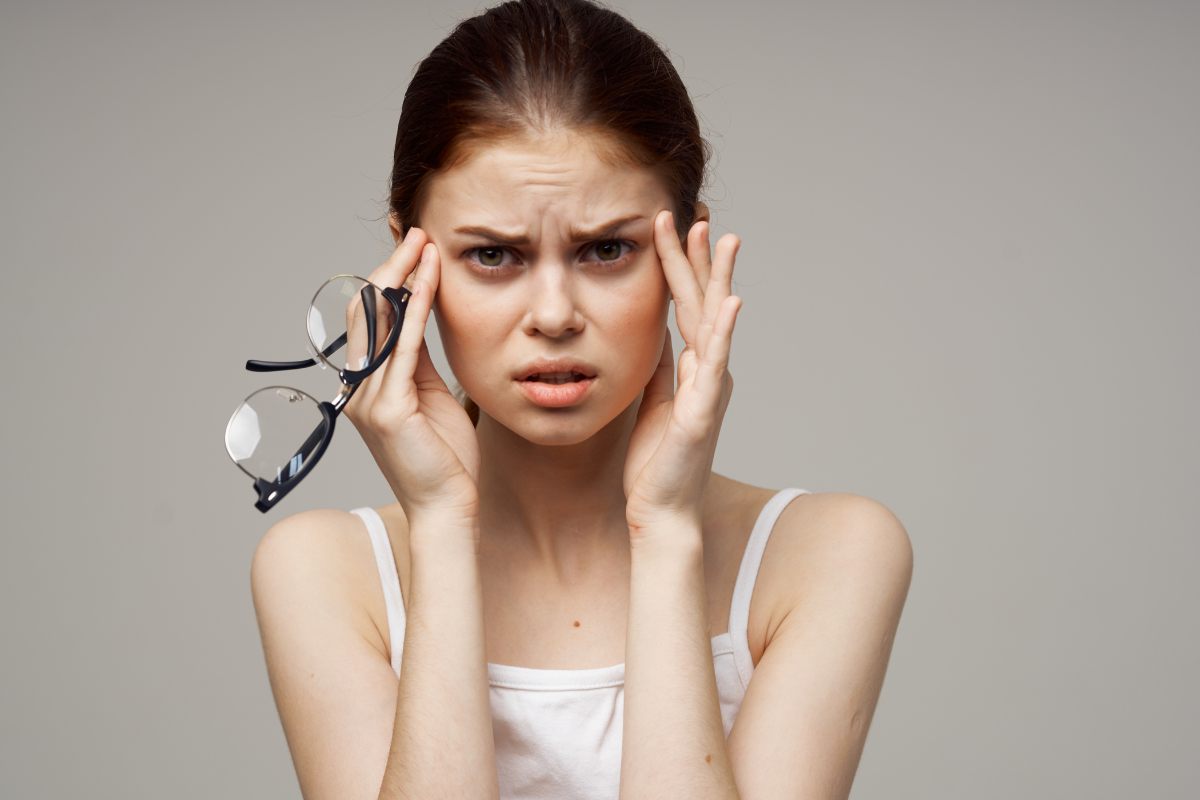 Una mujer con cara de preocupación porque tiene problemas con la vista, miopía o astigmatismo.