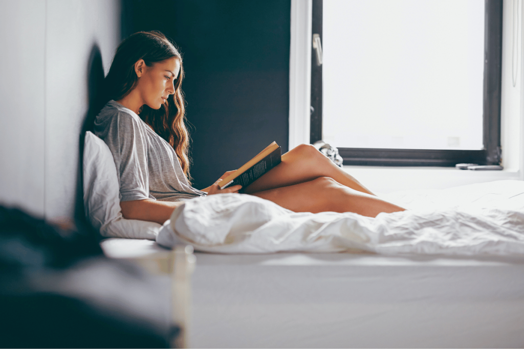 Mujer leyendo en la cama por la mañana.