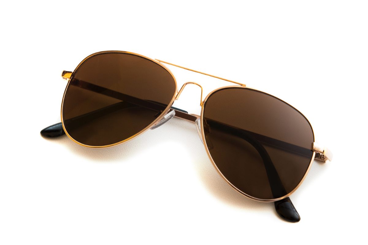 Unas gafas de sol, estilo aviador, con montura dorada y cristales marrones.
