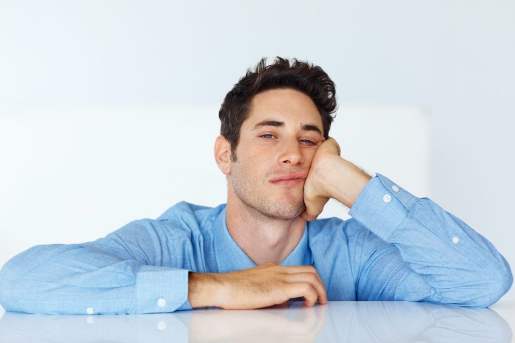 Un hombre joven que parece estar aburrido.
