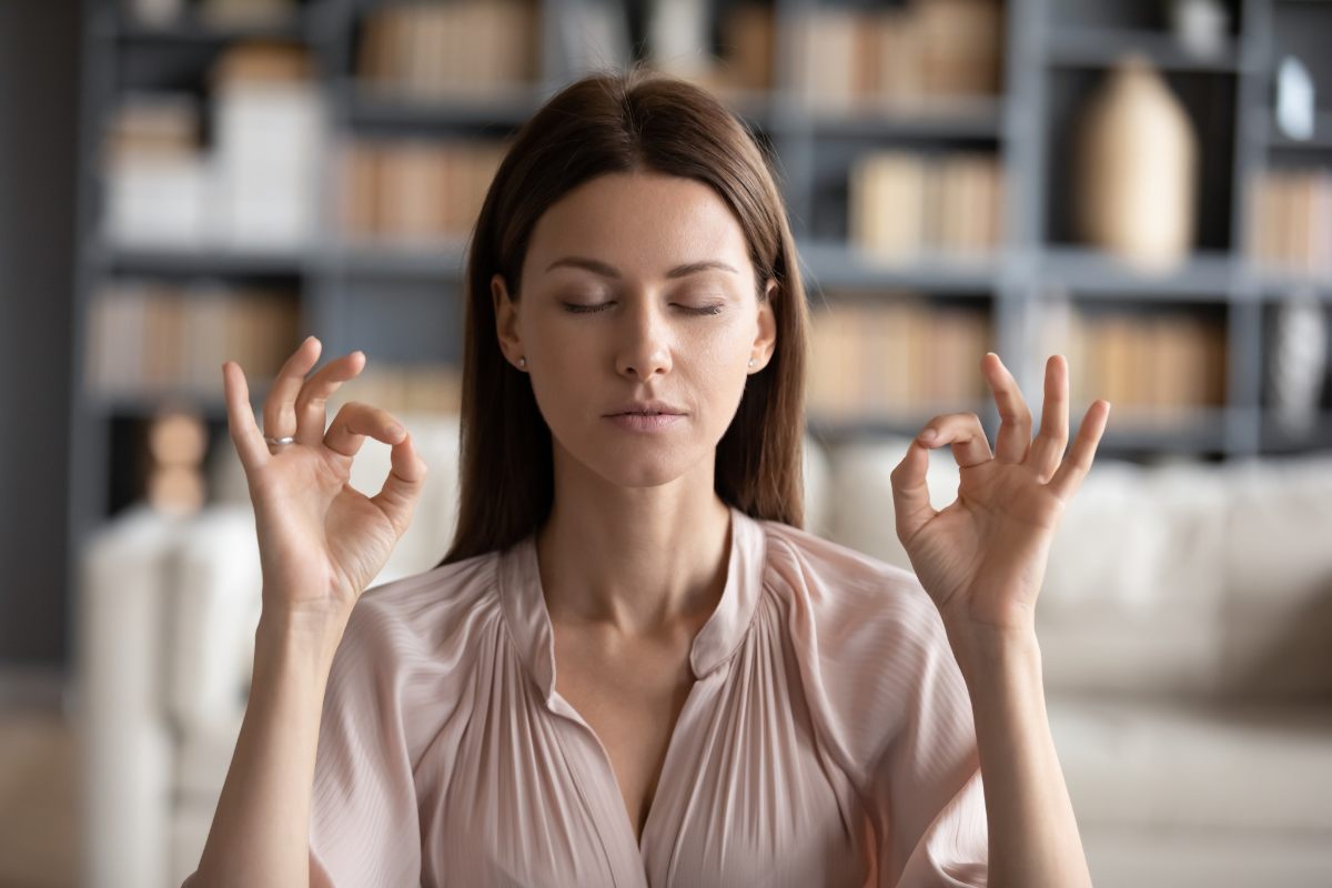 Una mujer meditando buscando paz interior en un momento om.