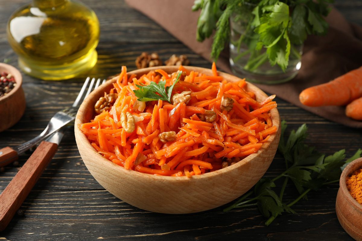 Un cuenco con una ensalada de zanahoria con nueces.