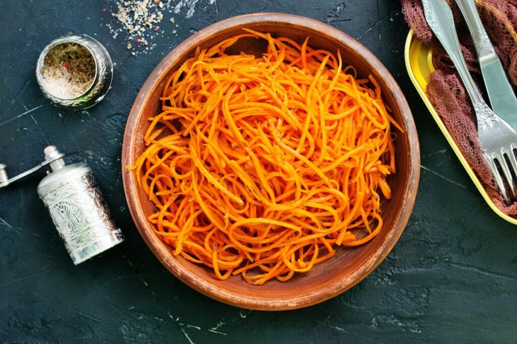 Un cuenco con una ensalada de zanahoria sencilla.