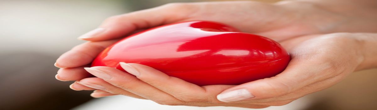 Las manos de una mujer sujetan una caja en forma de corazón.