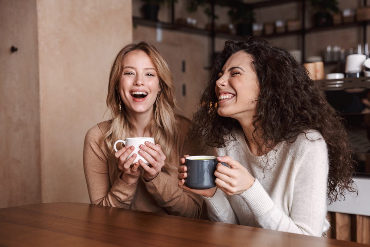 Dos mujeres jóvenes hablando y riendo.
