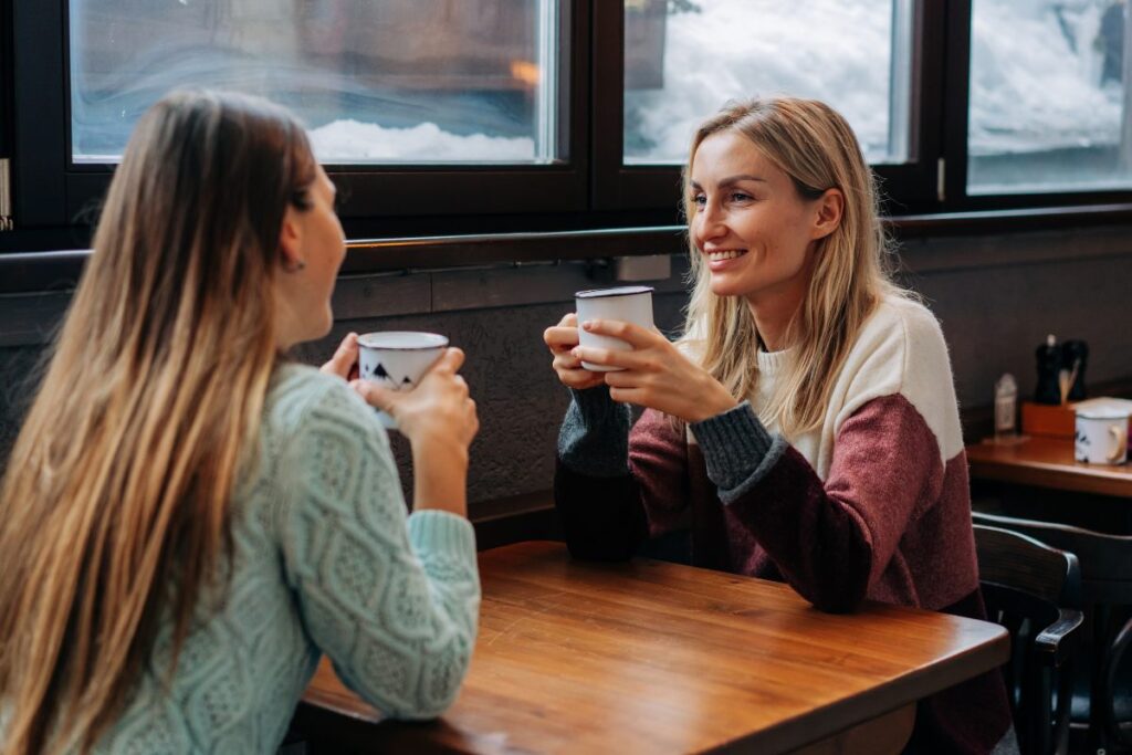 Dos amigas tomando café y charlando en un día invernal.