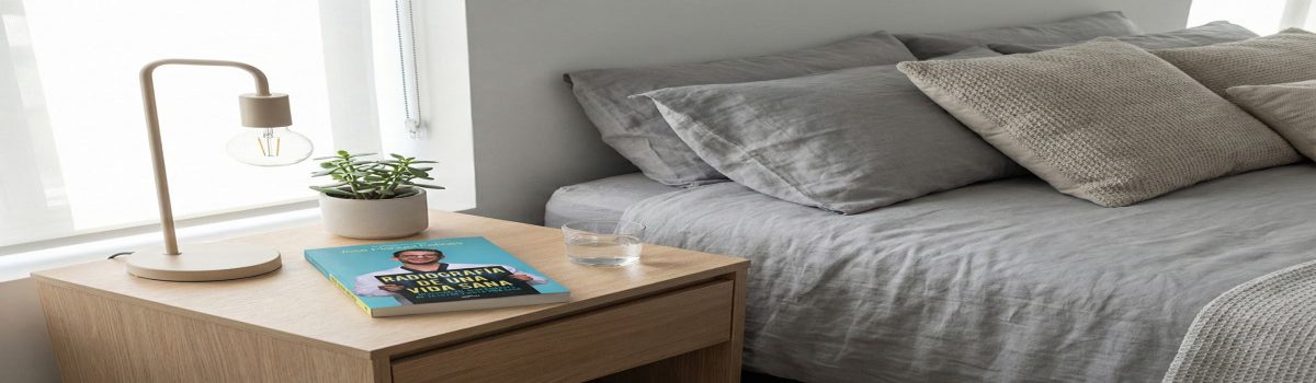 El libro titulado Radiografía de Una Vida Sana: Descubre la Ciencia Detrás de la Salud y la Felicidad colocado en la mesilla de un dormitorio moderno.