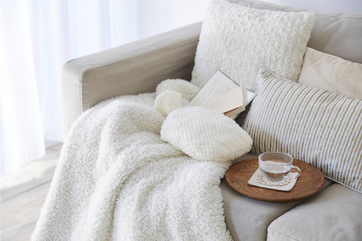 Rincón de lectura cómodo y recogido, decorado en tonos claros.